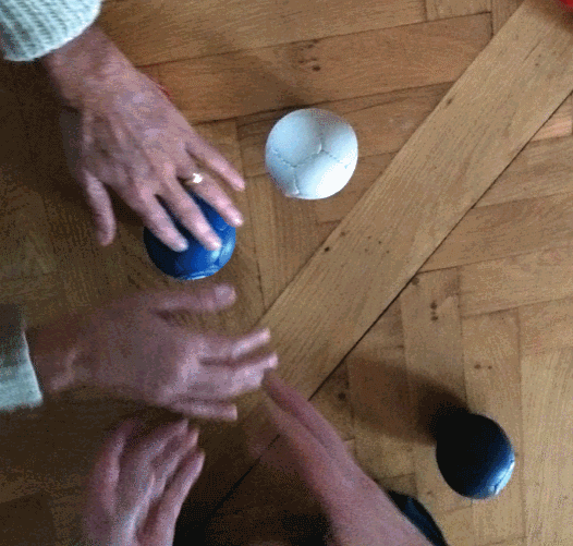 Игрок ощупывает мяч на корте Бочча